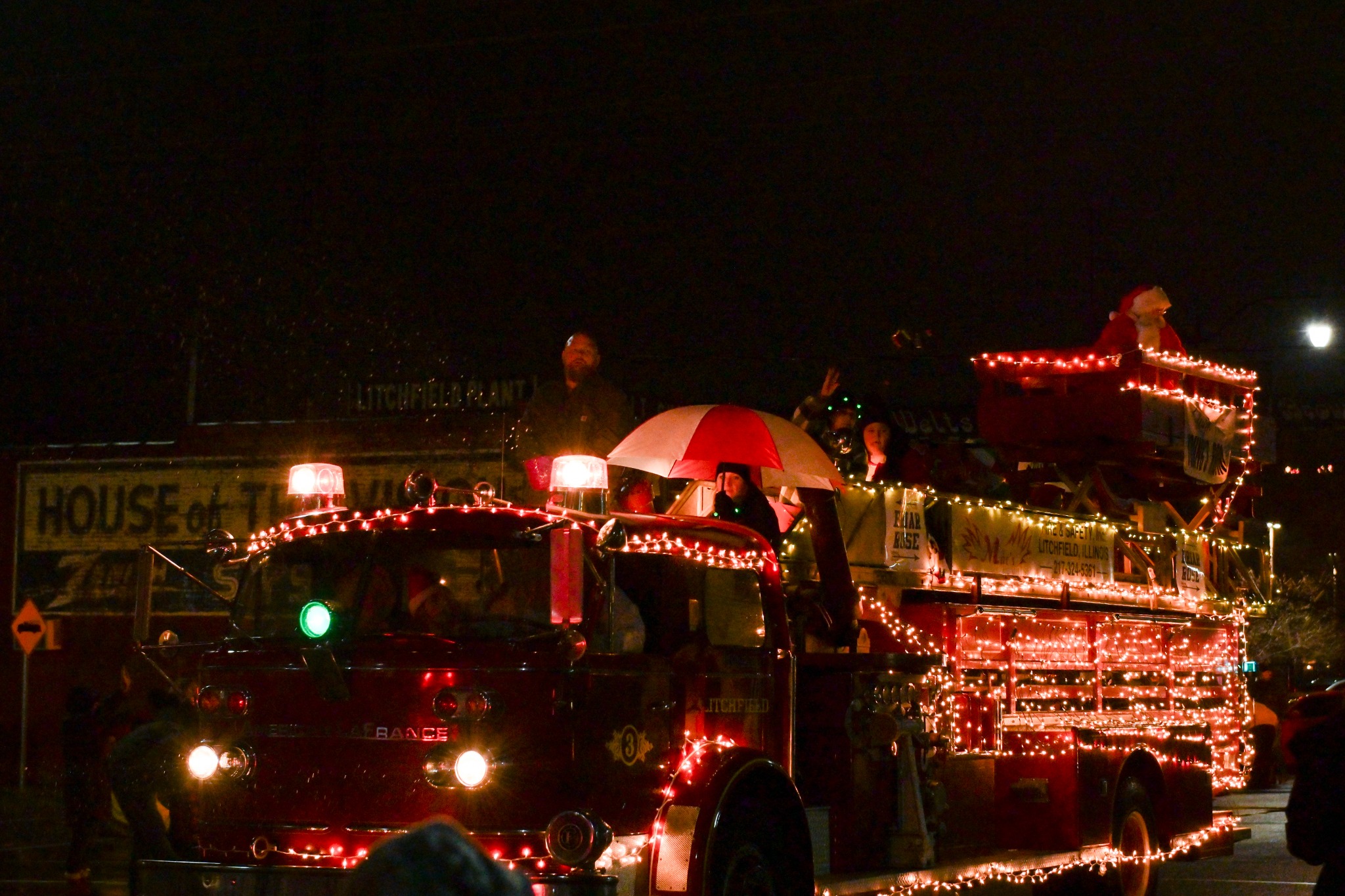 Christmas parade fire truck wrapped in lights with Santa riding above