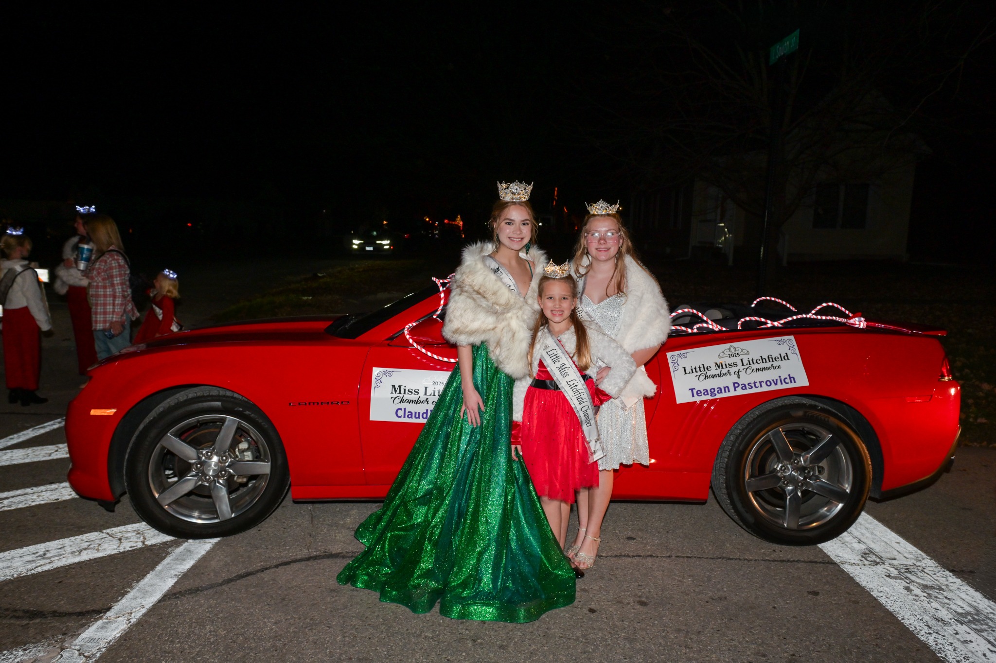 Litchfield Chamber royalty posing by a red parade car