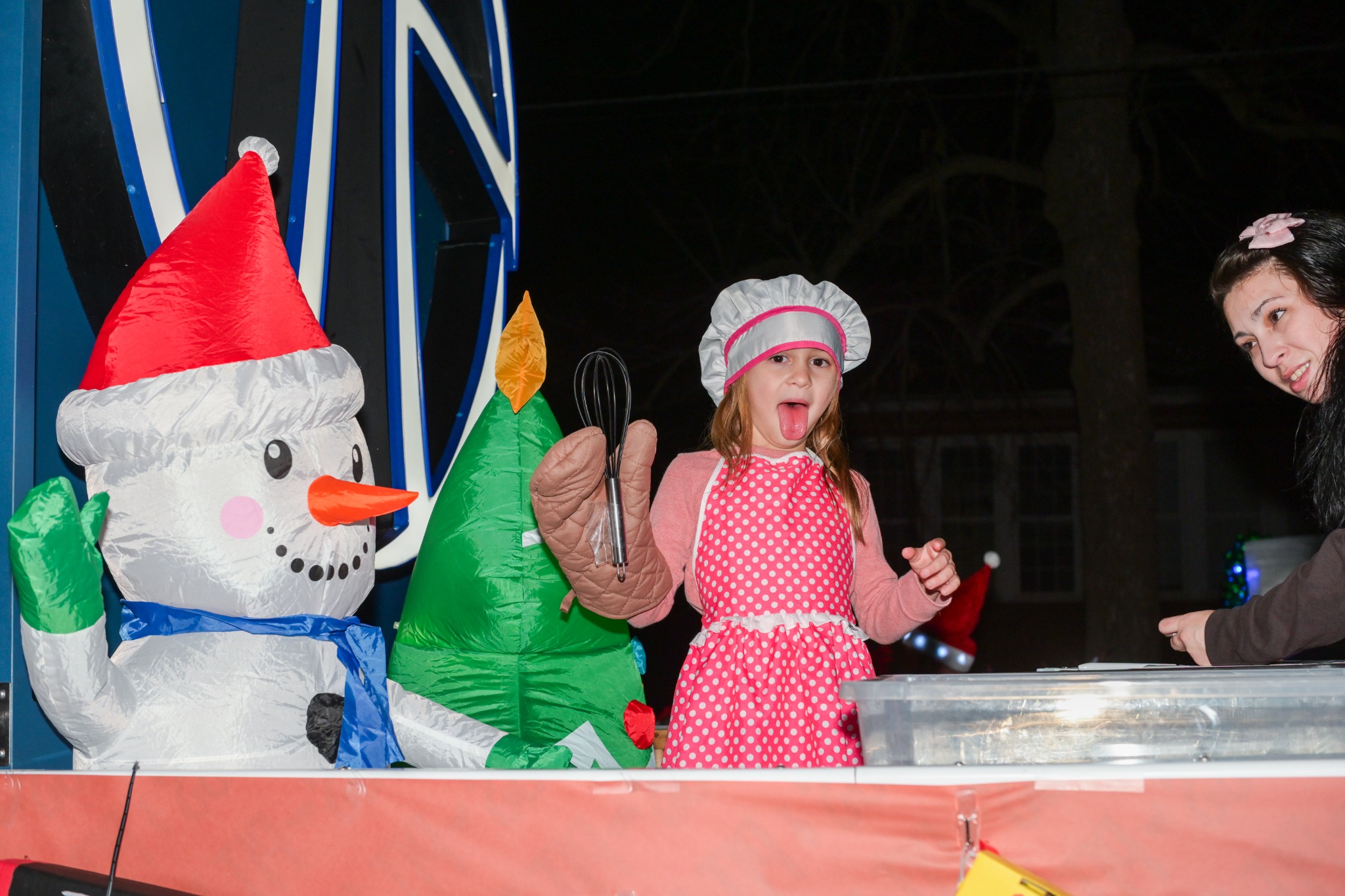 Young baker-themed participant on a Christmas parade float