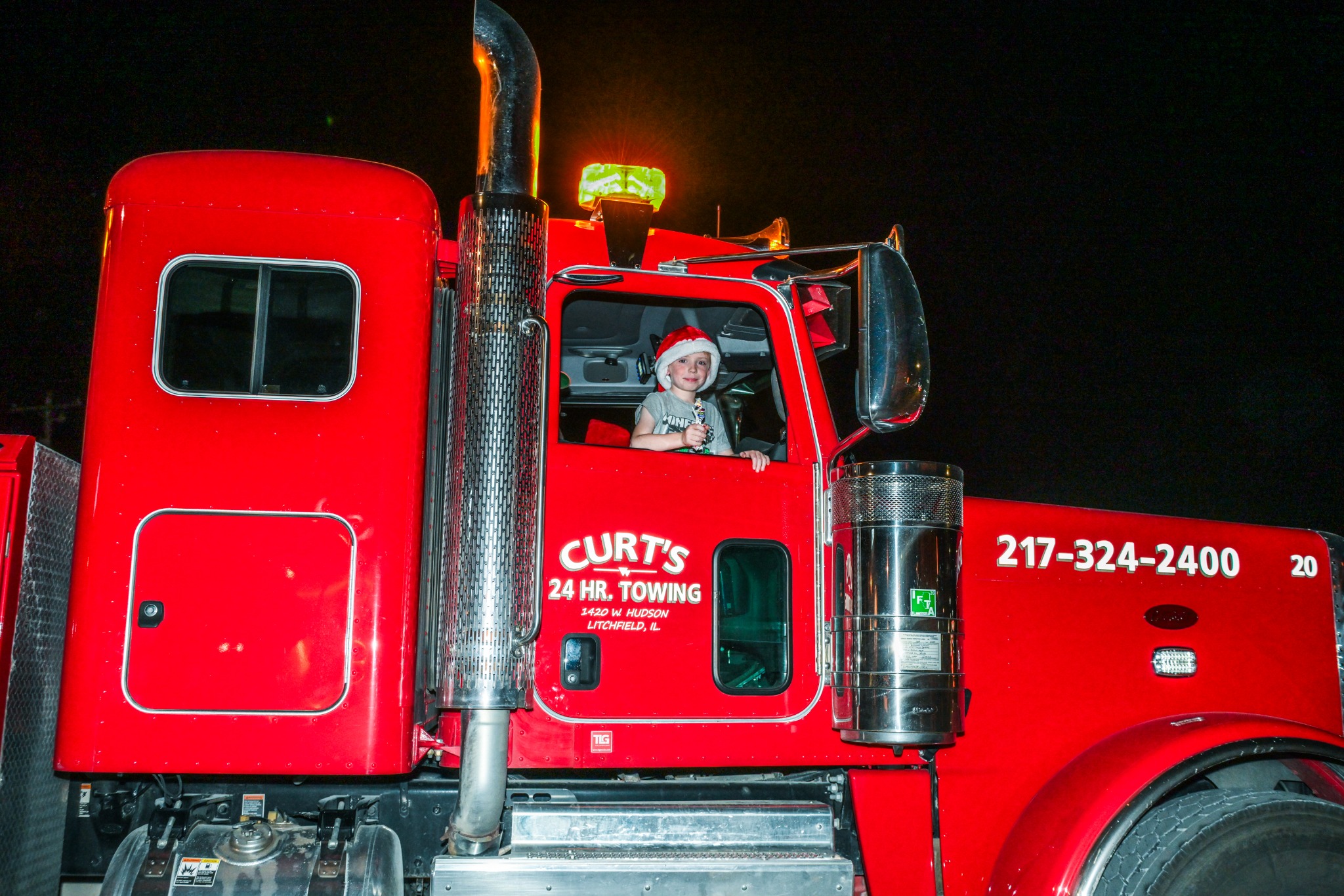 Child waving from Curt’s 24 Hr. Towing truck during the parade