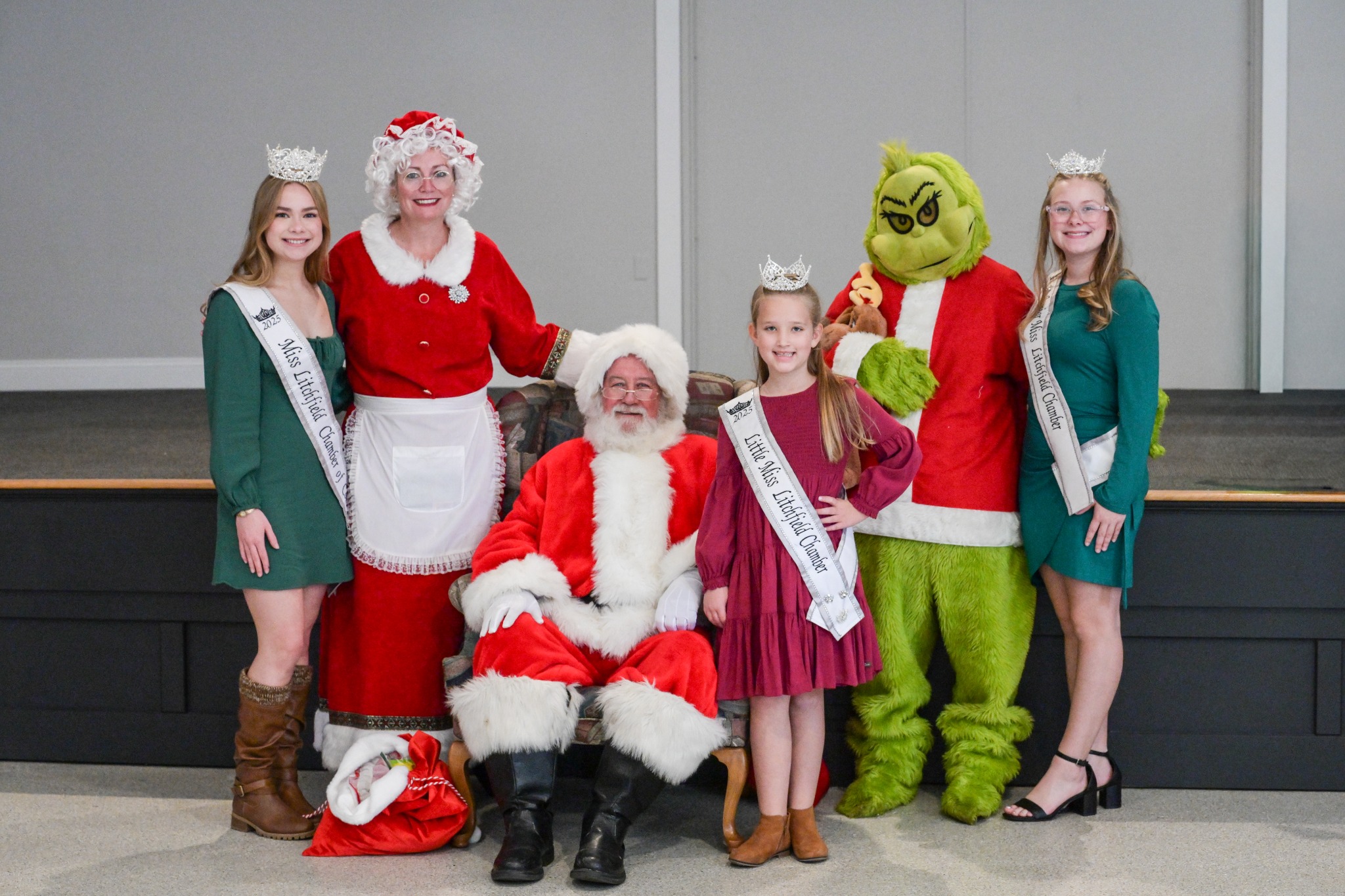 Festival of Trees group photo with Santa, Mrs. Claus, Grinch, and royalty