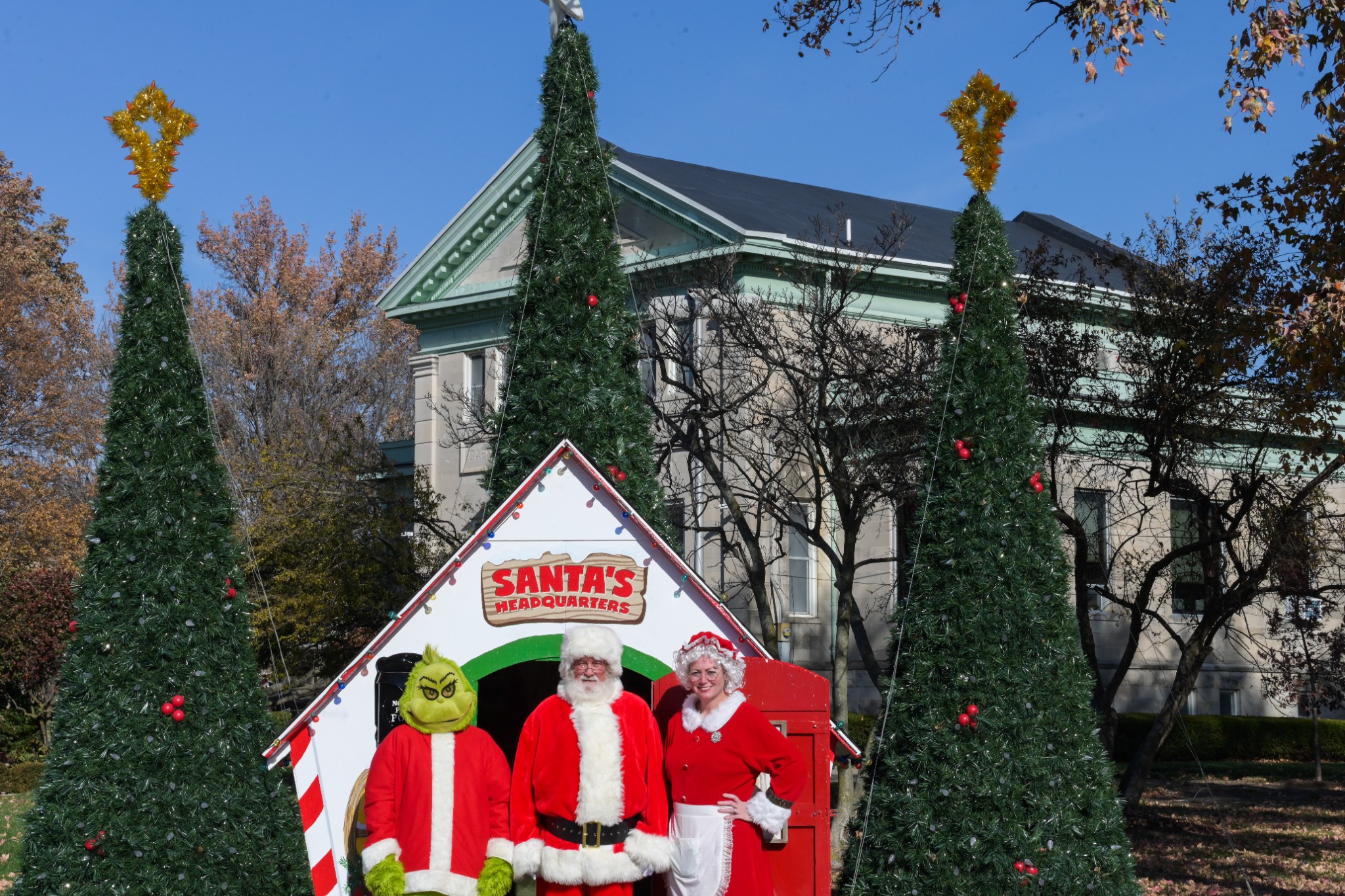Wide photo of Santa, Mrs. Claus and the Grinch at Santa's Headquarters