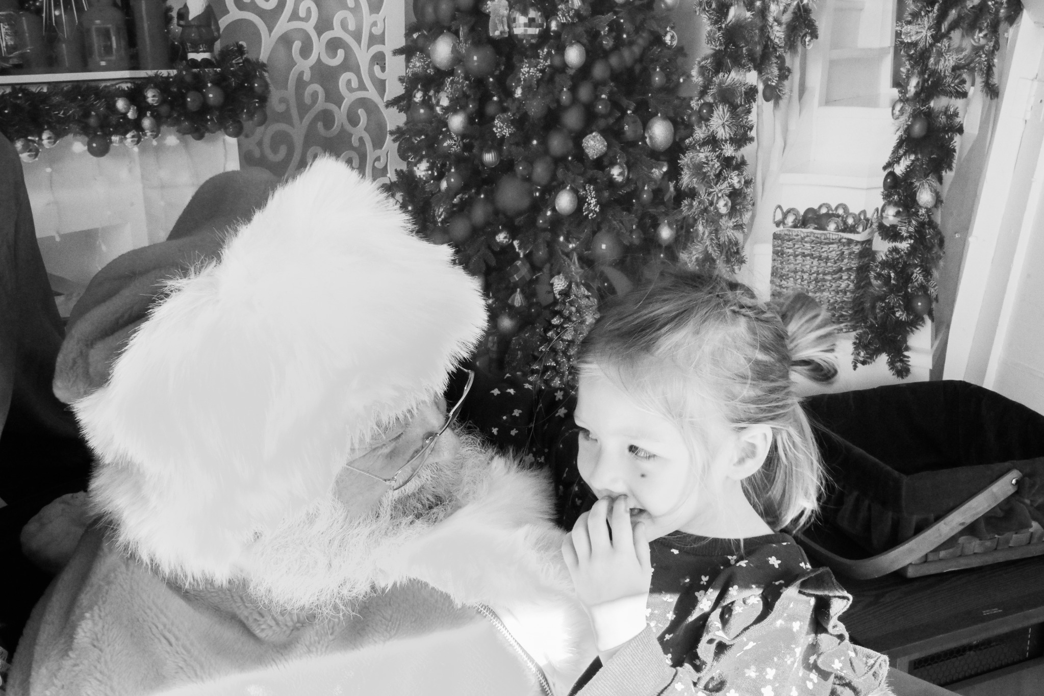Black and white photo of Santa visiting with a child